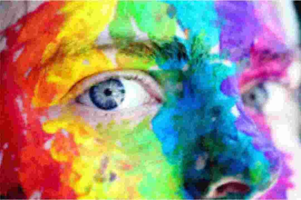 raw image of a man with blue eyes with multi colors on his face